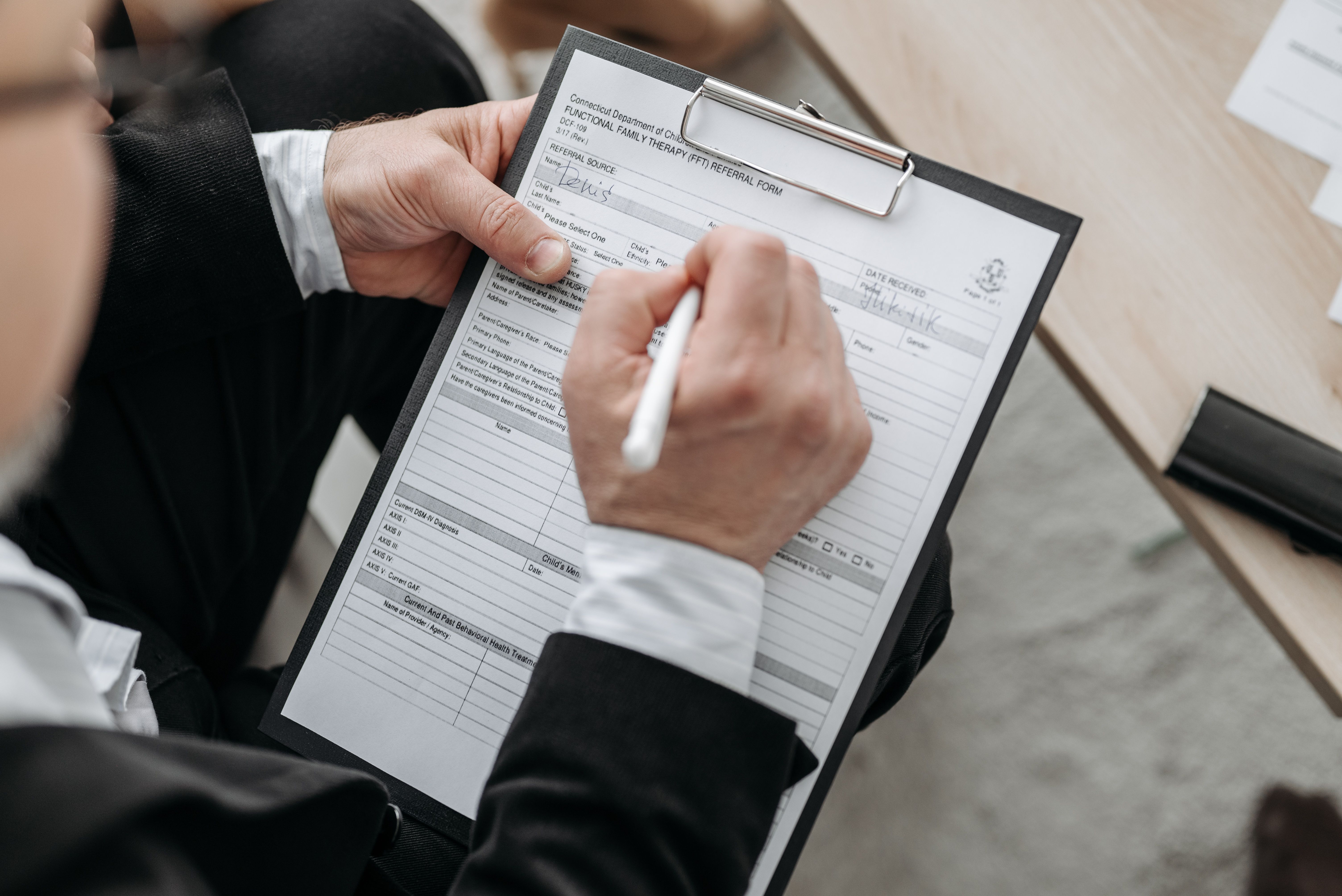 Person signing a formal legal document, representing filing a diesel emissions compensation claim