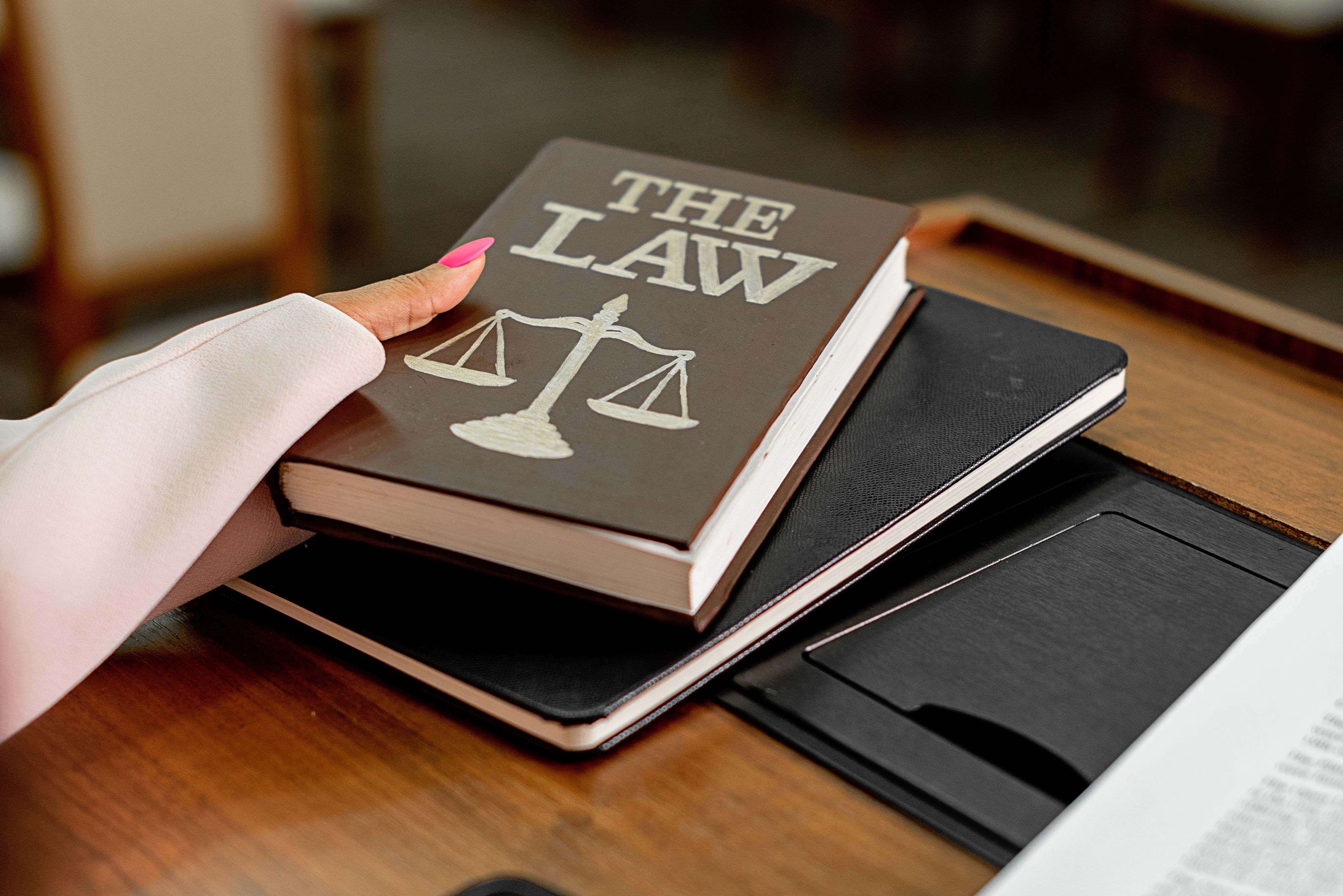 Law book on a wooden desk with scales of justice representing complex litigation casework