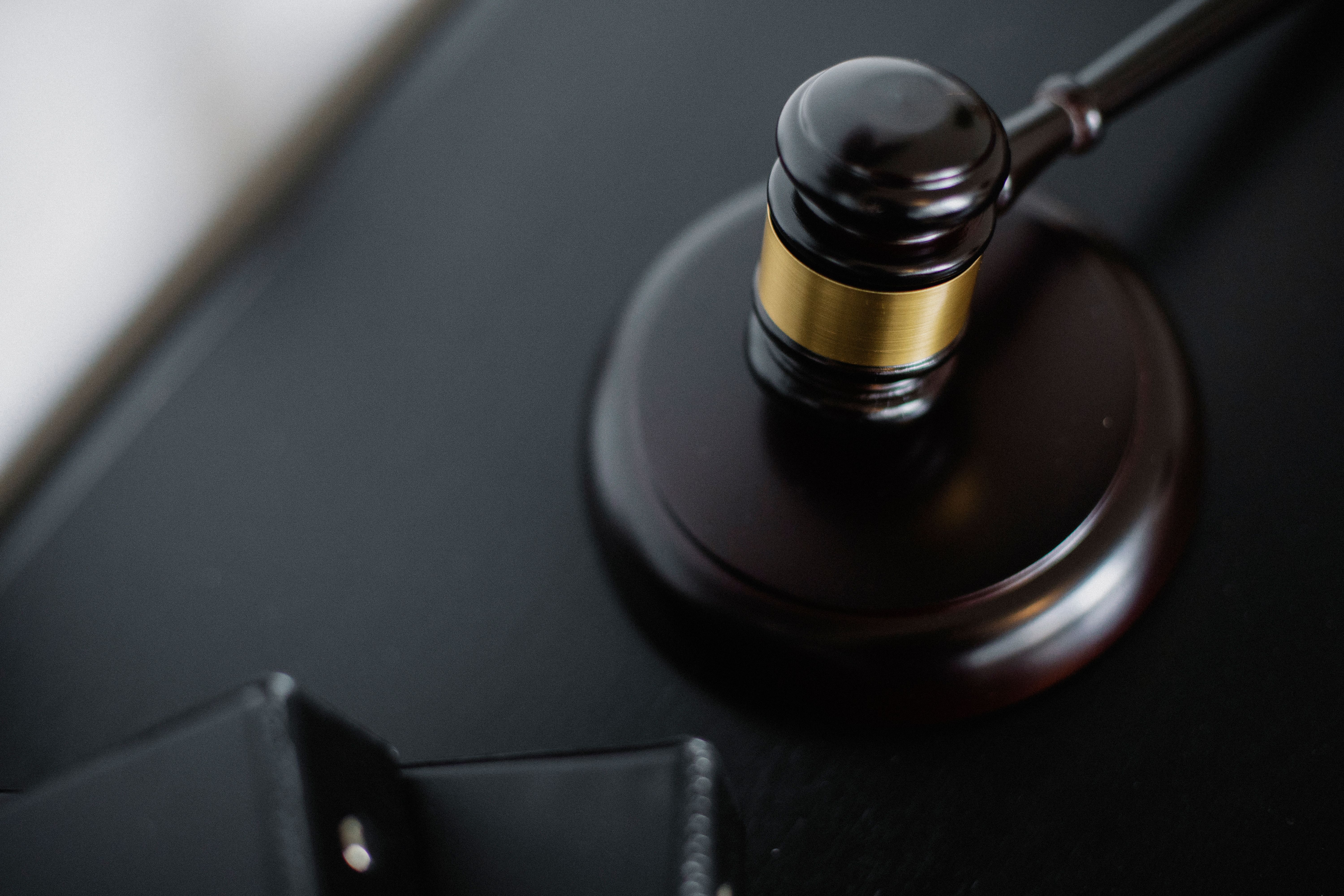 Wooden gavel and case folders on a courtroom table symbolizing litigation proceedings