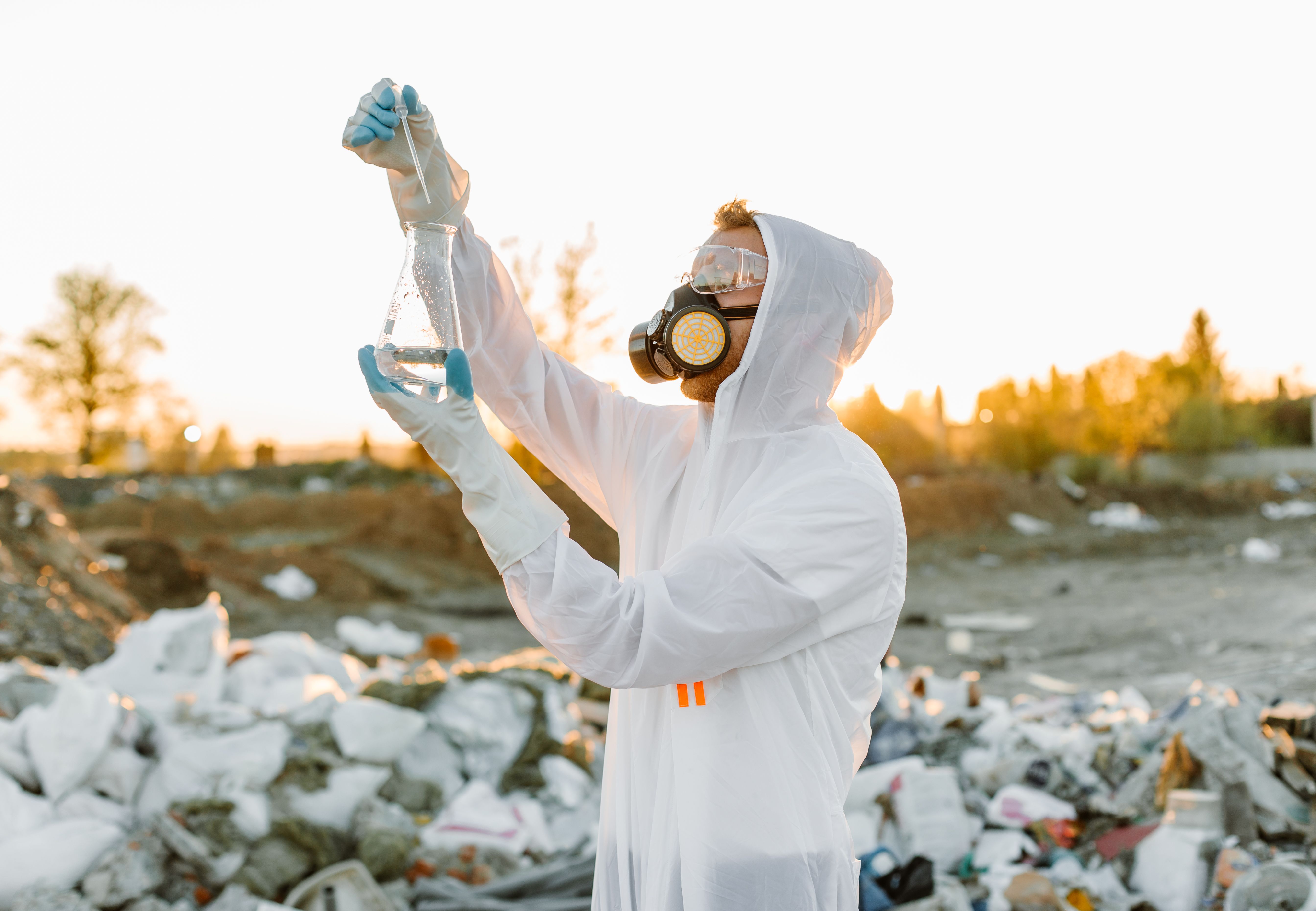 Scientist in protective gear collecting samples at a waste site, illustrating evidence gathering in environmental cases.