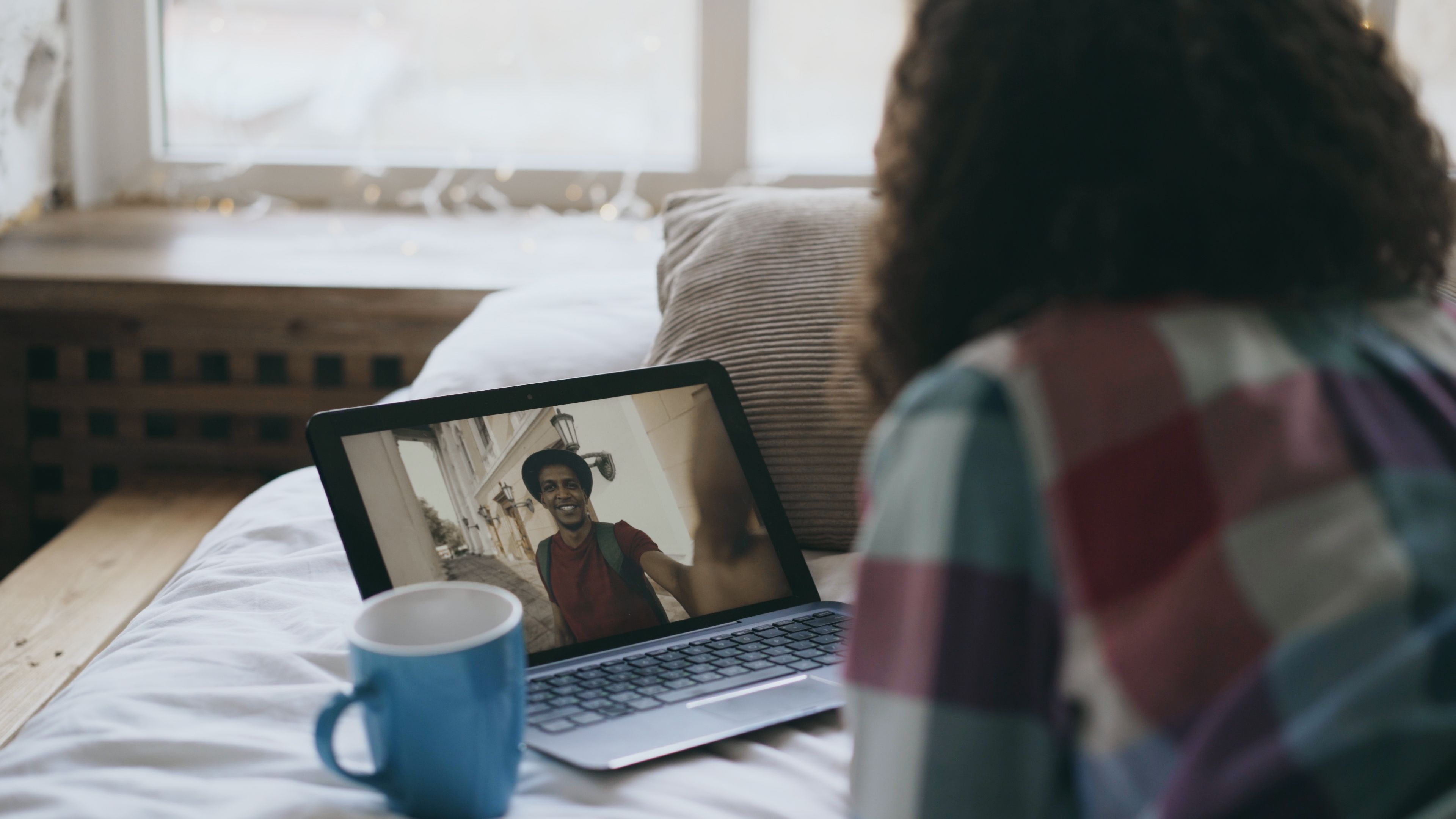 Woman smiling during a relaxed video call at home, a small everyday moment of digital connection.