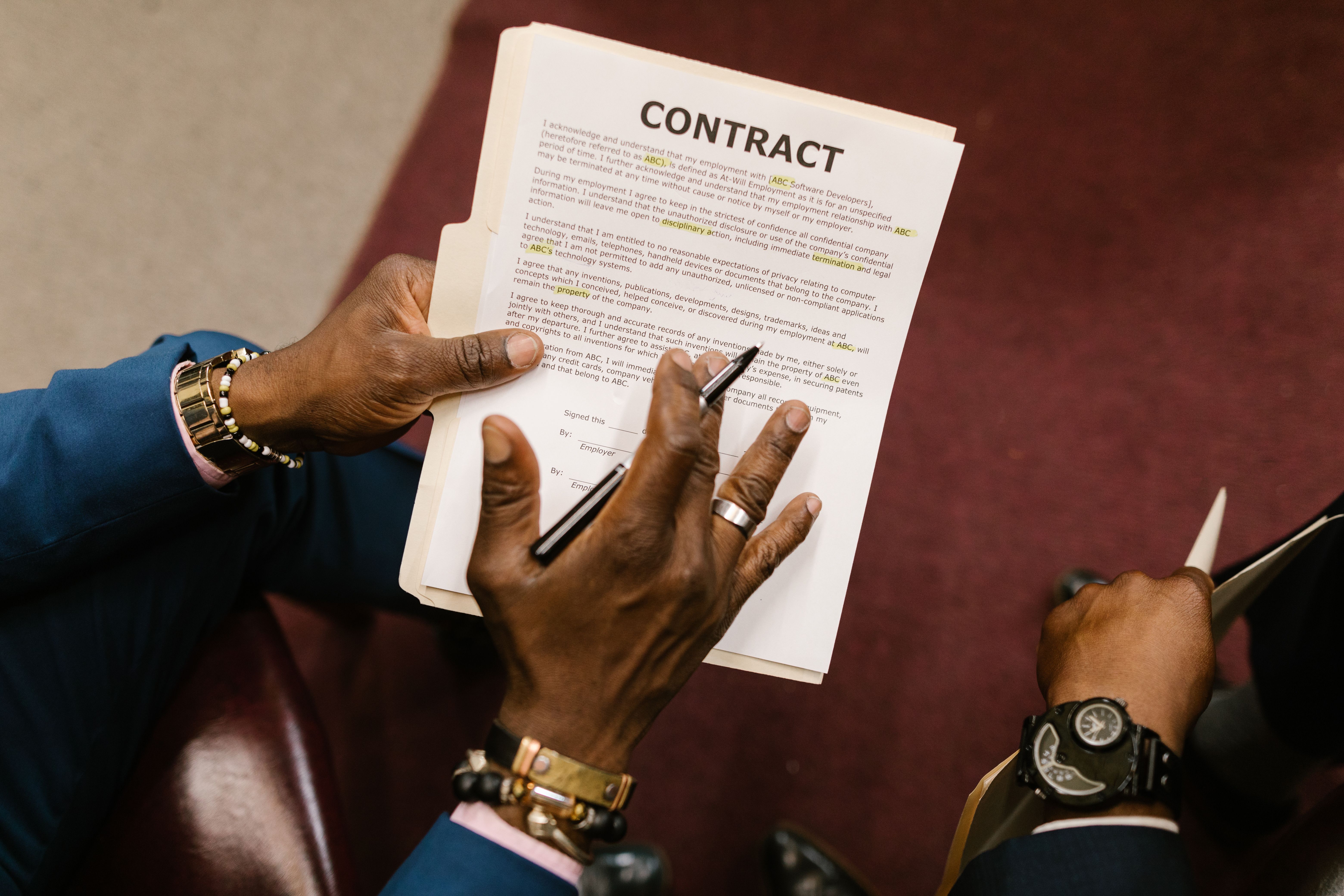 Two businessmen reviewing and signing a funding agreement in an office setting
