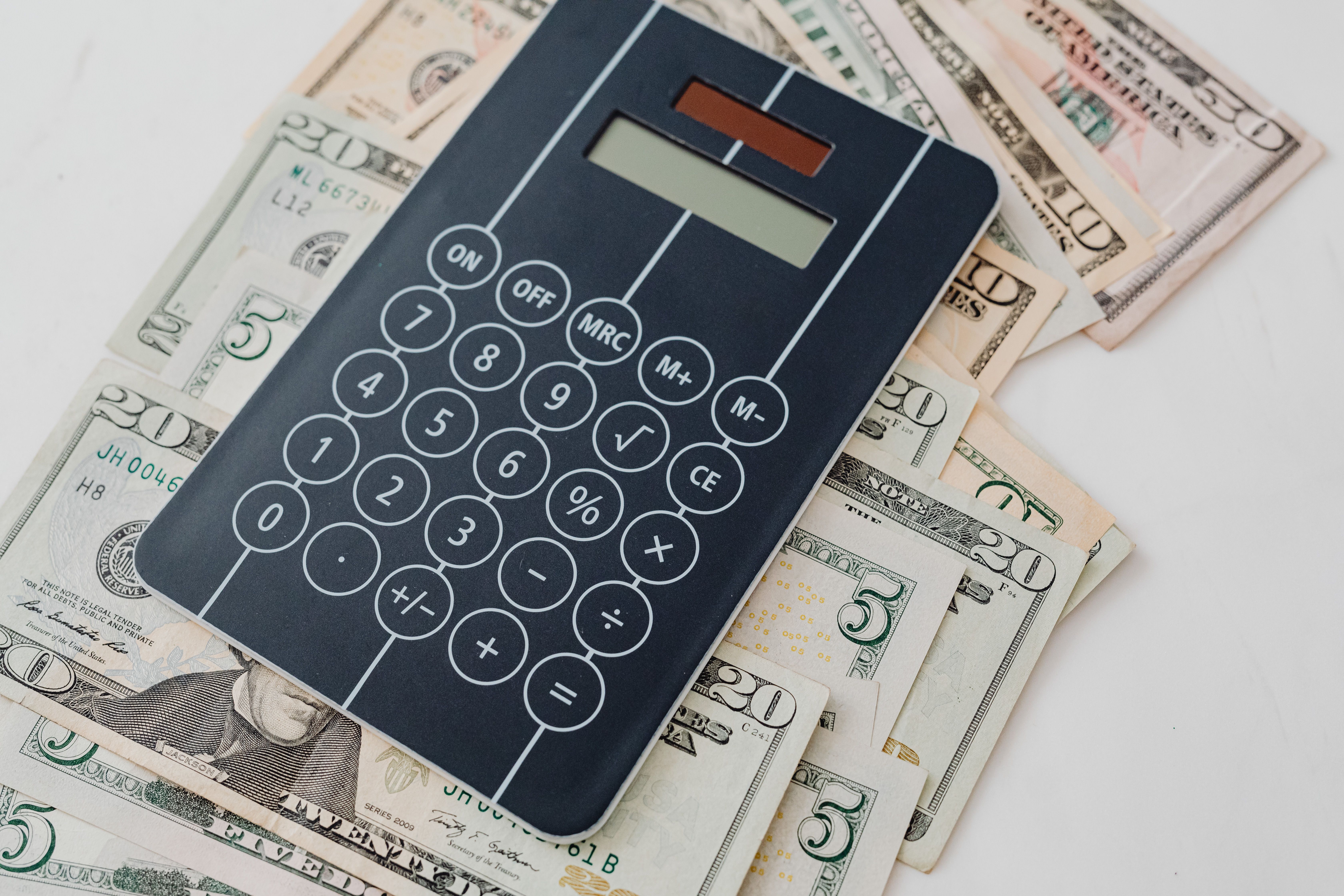 Close-up of a calculator atop US dollar bills symbolizing litigation financing and budgeting